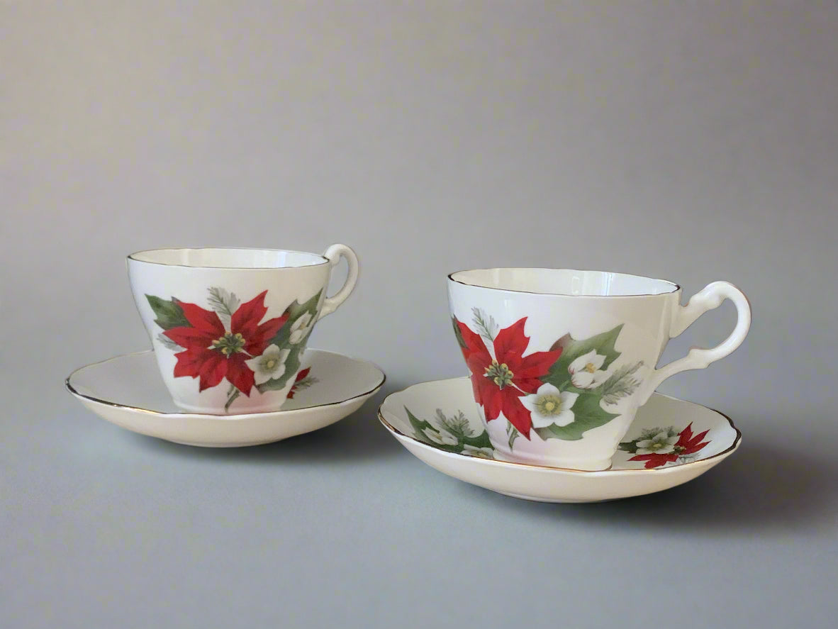 Two white teacups with red poinsettia flowers