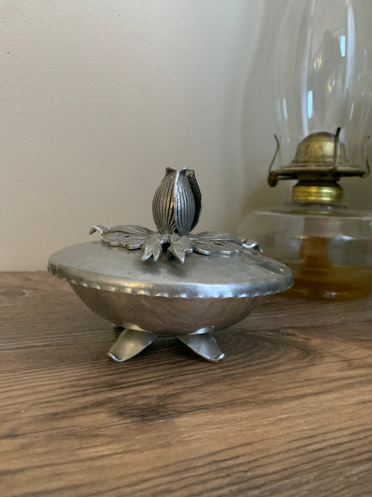 A small covered dish with a flower shape handle