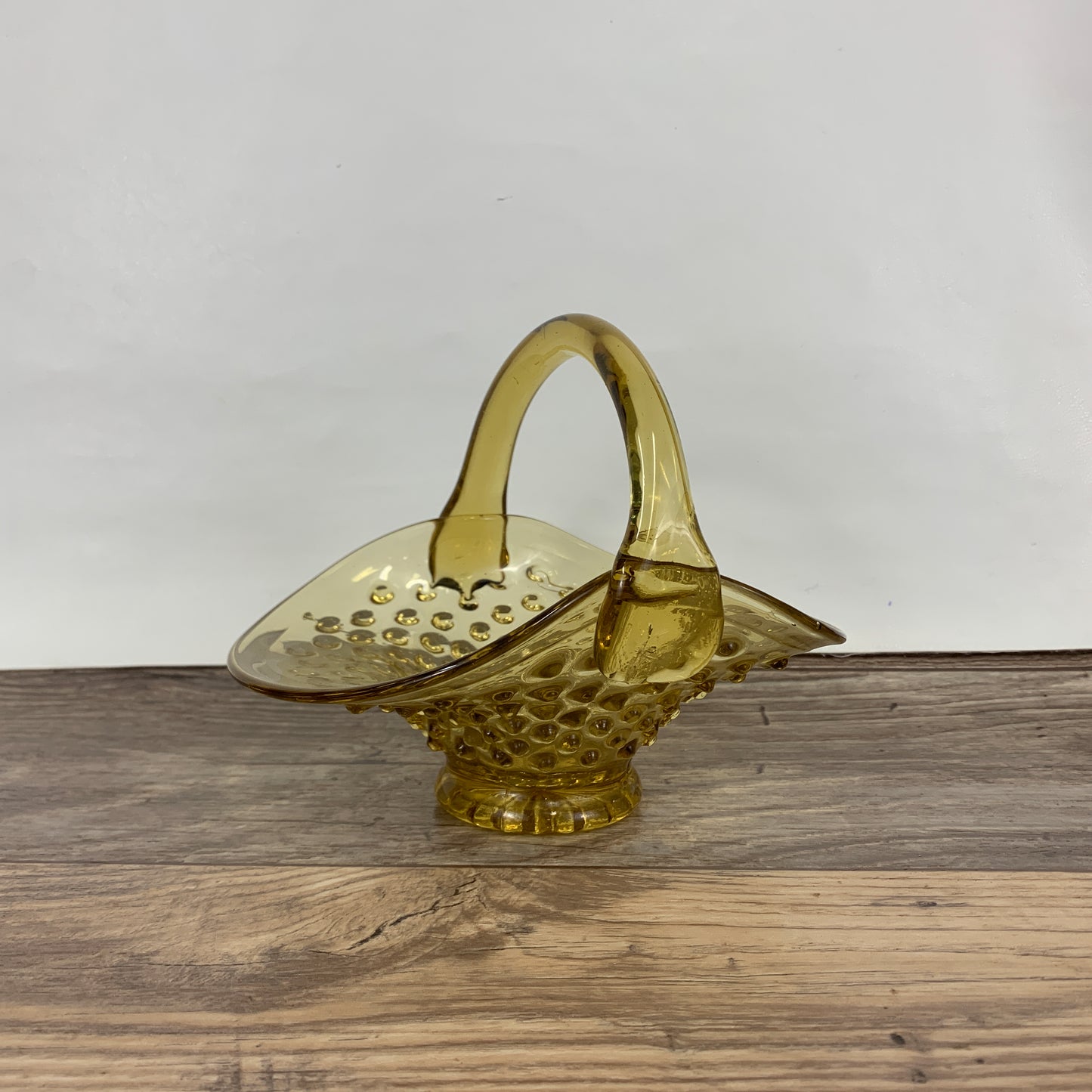 A small amber glass basket with a hobnail pattern 