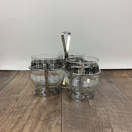 Three cups with black and white design and a silver metal holder