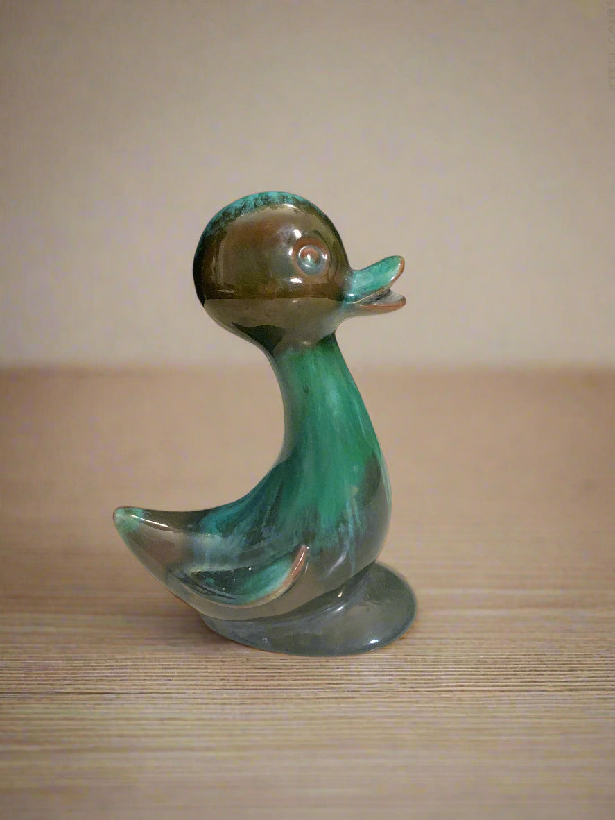 A pottery duck with a green drip glaze