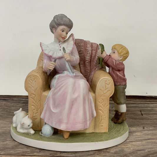 Grandma knitting in a chair with her grandson showing a frog.