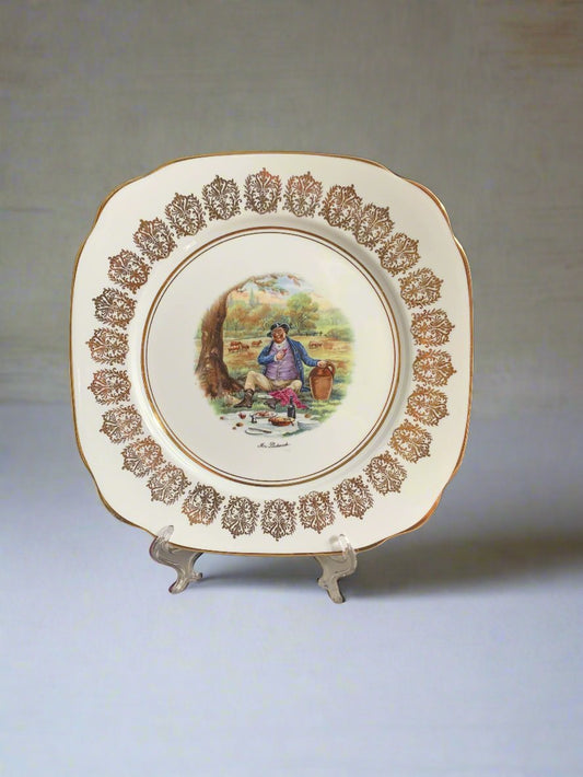 A square shaped china plate with a centre image of Mr. Pickwick having a picnic.