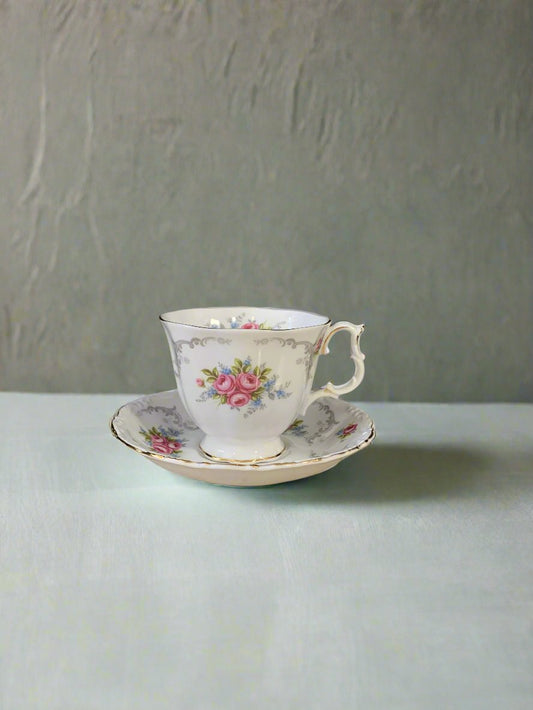 White teacup decorated with pink cabbage roses