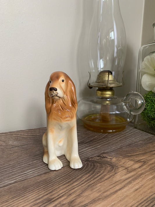 A porcelain figurine of a dog sitting