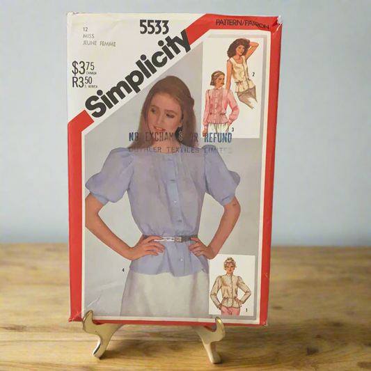 A vintage Simplicity sewing pattern on a stand